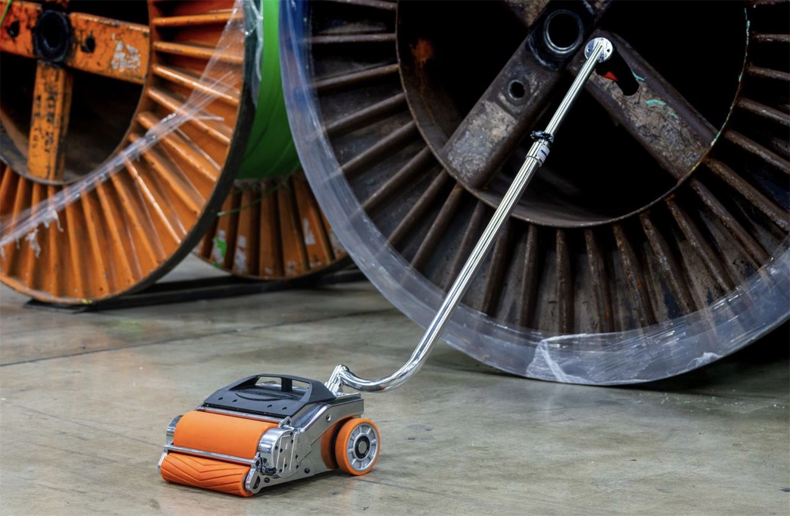 Movedor de rollos PowerRoll junto a carretes de cable en una planta